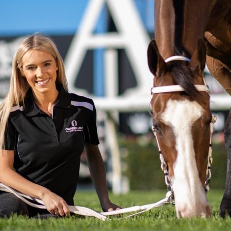 Brittany Taylor sitting on grass with horse